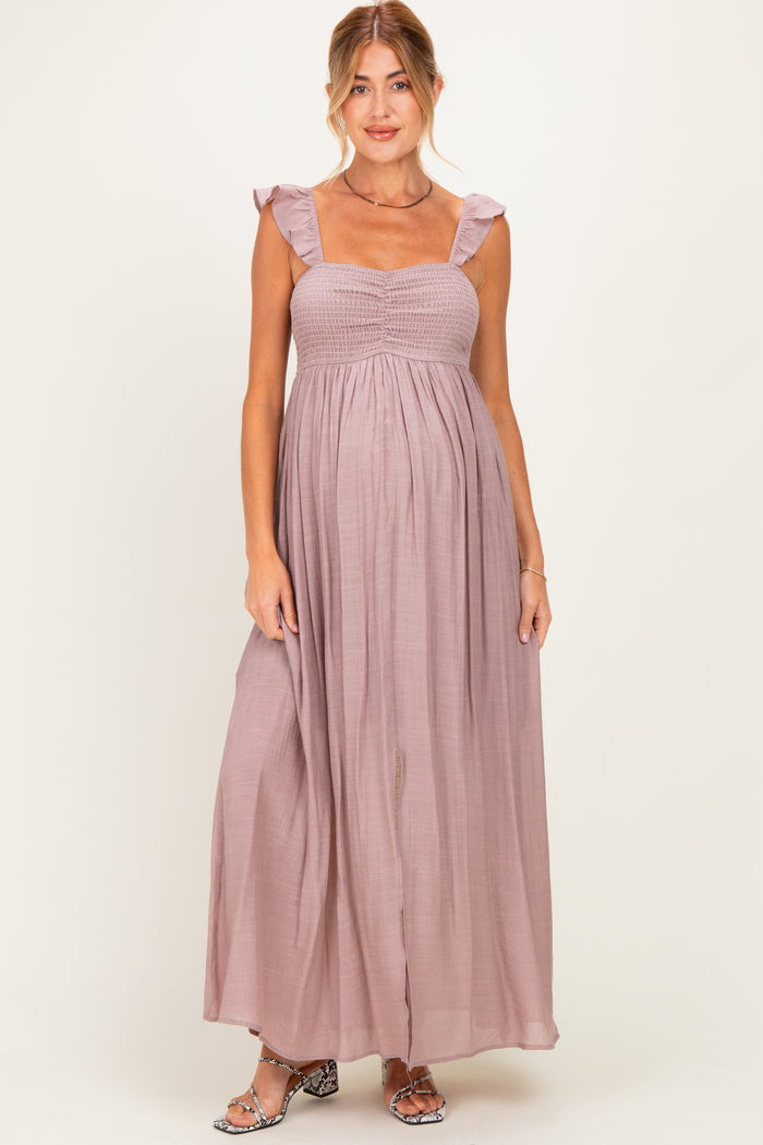 woman wearing a mauve maternity maxi dress with ruffle details and a smocked bodice, showcasing her baby bump