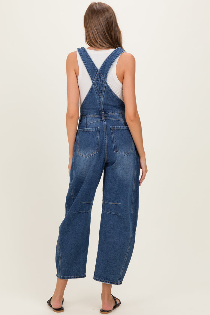 woman wearing a pair of blue denim maternity overalls with wide legs, seen from the back