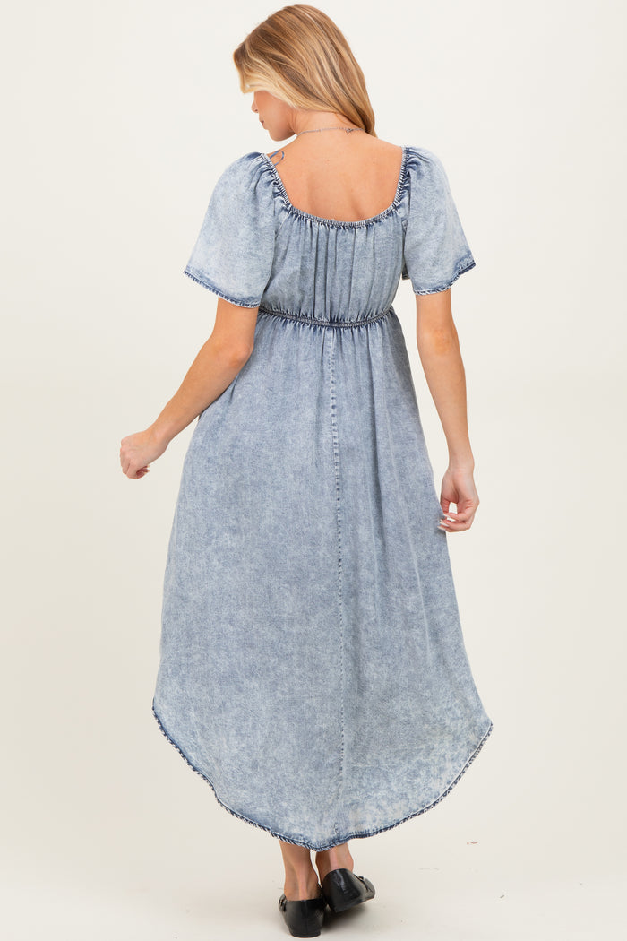 woman wearing a light wash denim maternity maxi dress with short puff sleeves and a smocked back