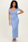 woman wearing a light blue short sleeve maxi dress with a v-neck and side slit