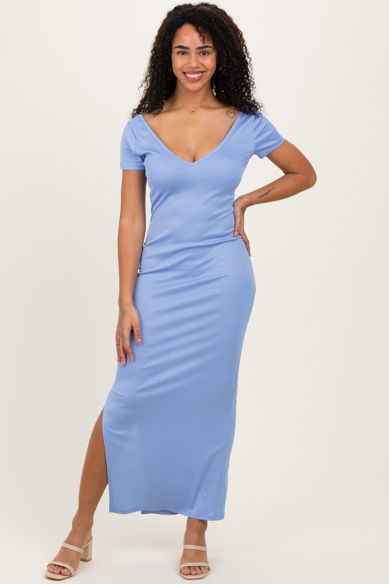 woman wearing a light blue ribbed maxi dress with a deep v-neck and a thigh-high slit