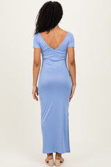 woman wearing a light blue short sleeve maxi dress with a deep v-back, seen from the back