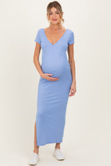 woman wearing a light blue maternity dress with a deep v-neck and side slit, showing her baby bump