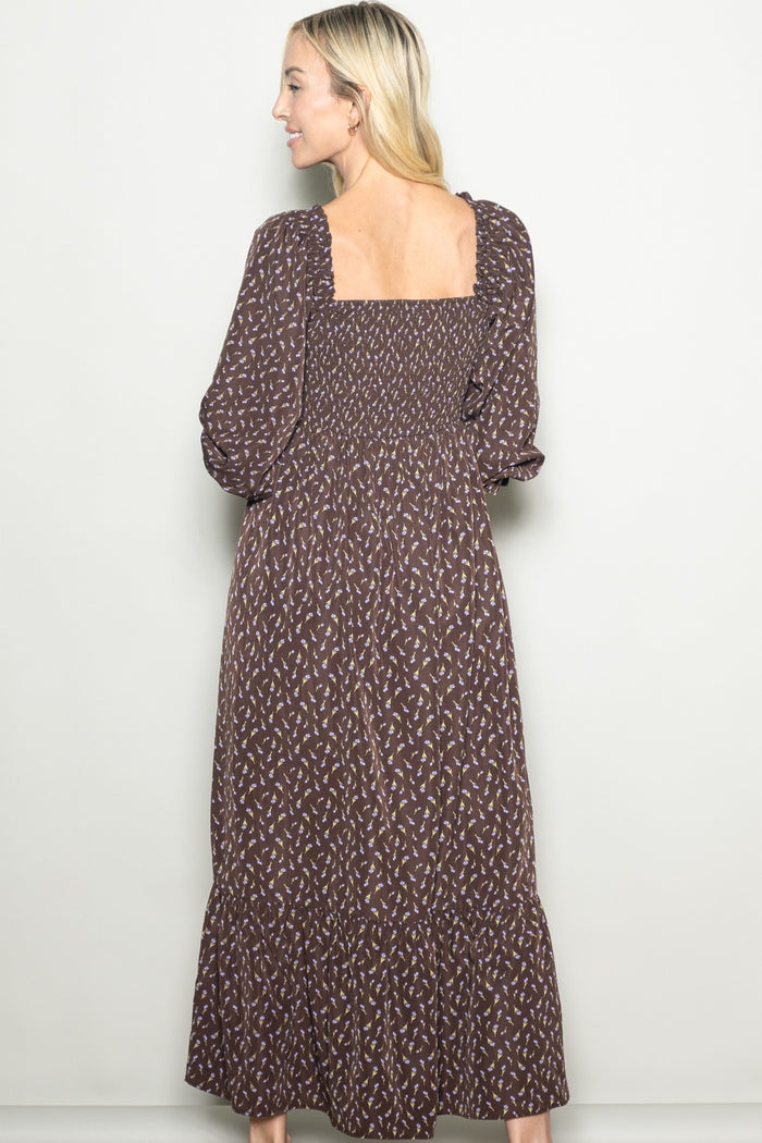 woman wearing a brown floral maxi dress with long sleeves and a square back design