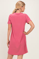 woman wearing a pink short sleeve ribbed dress, shown from the back, with a relaxed fit and a round neckline