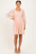 woman wearing a light pink smocked mini dress with puff sleeves and textured dots