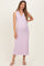 woman wearing a light pink sleeveless maternity dress with a v-neck and ribbed texture, highlighting her baby bump