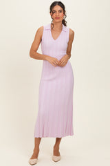 woman wearing a light pink sleeveless ribbed midi dress with a v-neck and collar, styled with neutral pointed-toe heels