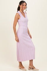 woman wearing a light pink sleeveless ribbed midi dress with a v-neckline and a fitted silhouette