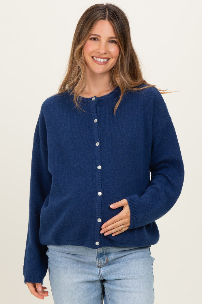 woman wearing a navy blue maternity cardigan with buttons and a baby bump visible