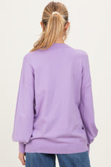 woman wearing a lavender oversized maternity sweater with balloon sleeves, viewed from the back