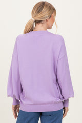 woman wearing a lavender oversized sweater with balloon sleeves, showing the back view