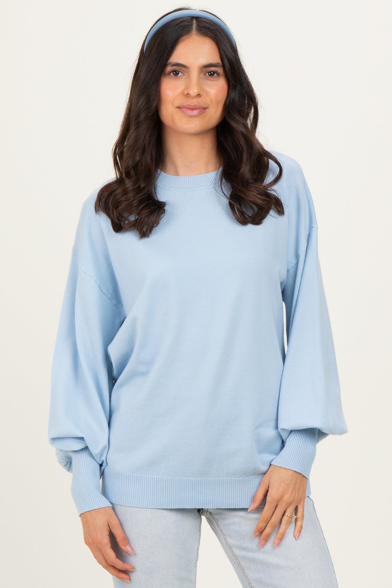 woman wearing a light blue oversized sweater with balloon sleeves and a matching headband