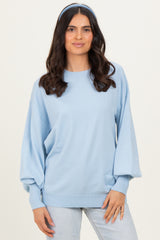 woman wearing a light blue oversized sweater with balloon sleeves and a matching headband