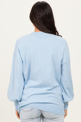 woman wearing a light blue oversized sweater with balloon sleeves, shown from the back
