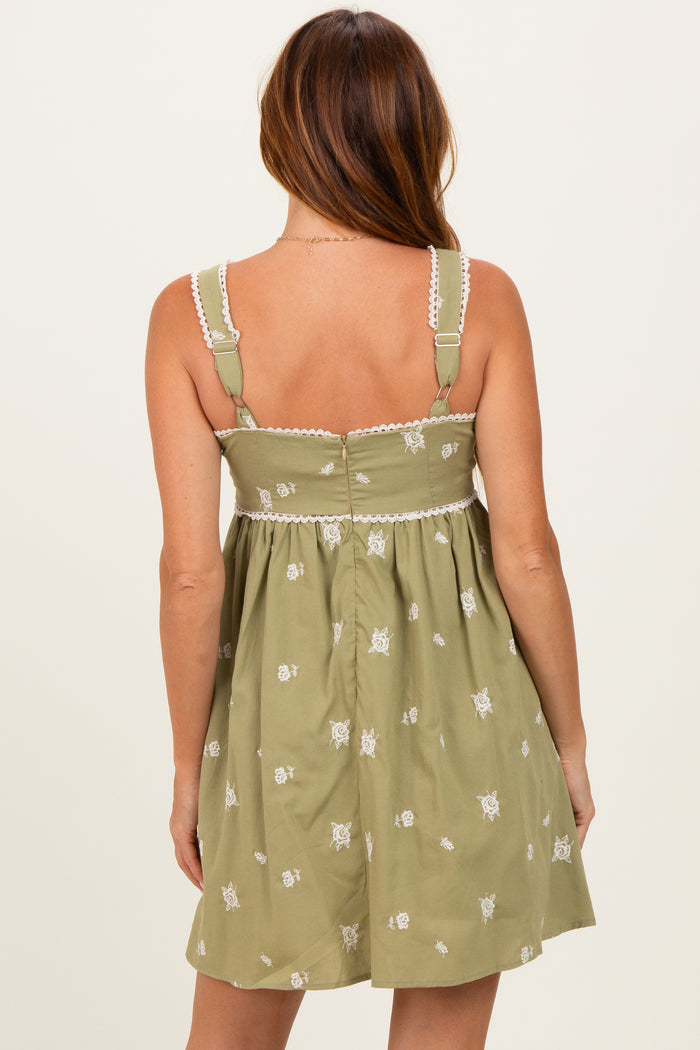 woman wearing a green embroidered sundress with adjustable straps and a fitted bodice