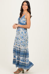 woman wearing a blue and white floral maxi dress with a tie front and tiered hem