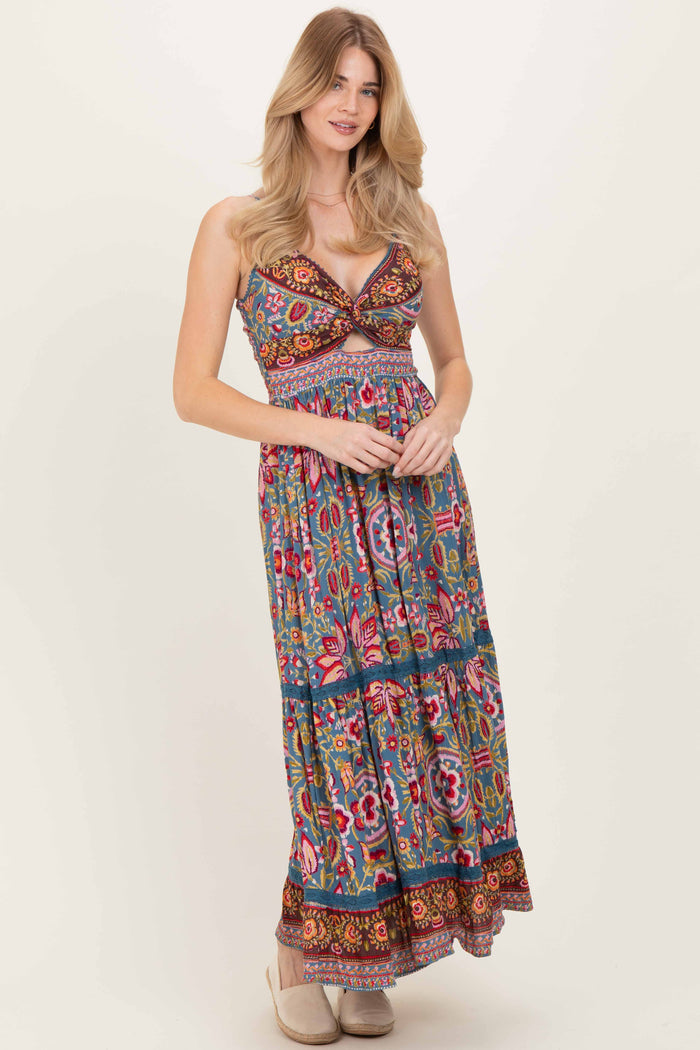 woman wearing a colorful floral maxi dress with a plunging neckline and a tiered skirt