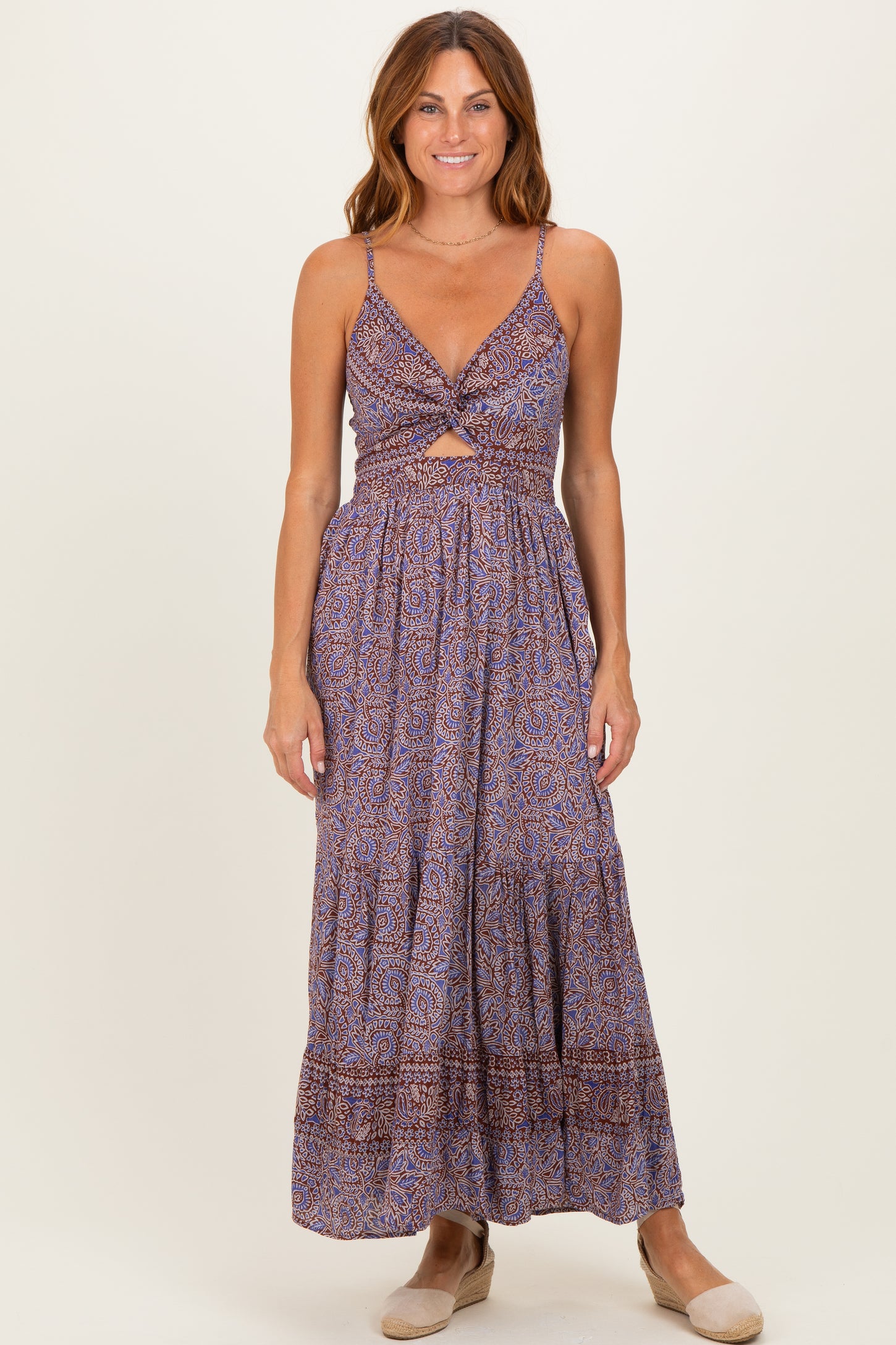 woman wearing a purple bohemian maxi dress with a twist front and cut-out details, standing on a neutral background