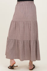 woman wearing a brown and white checked tiered maternity maxi skirt, showing the back view