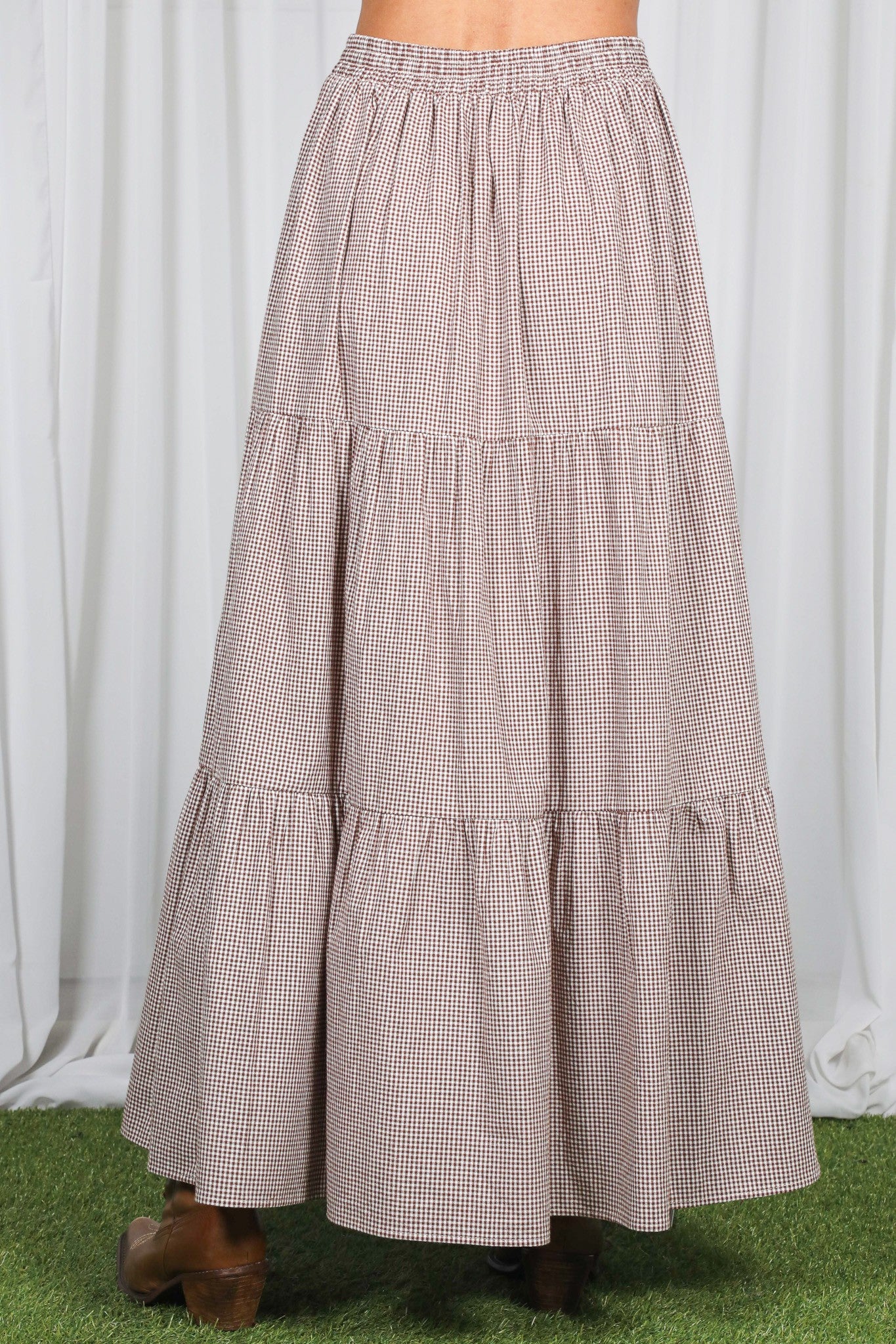 woman wearing a brown and white checked tiered maxi skirt with an elastic waistband
