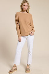 woman wearing a beige long sleeve top and white wide-leg jeans with tan espadrille sandals