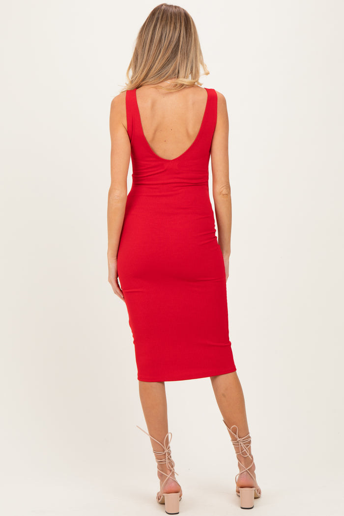 woman wearing a red ribbed maternity dress with a deep back neckline, showing a fitted silhouette