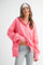 woman wearing a bright pink oversized pullover with a collar and long sleeves, paired with gray leggings