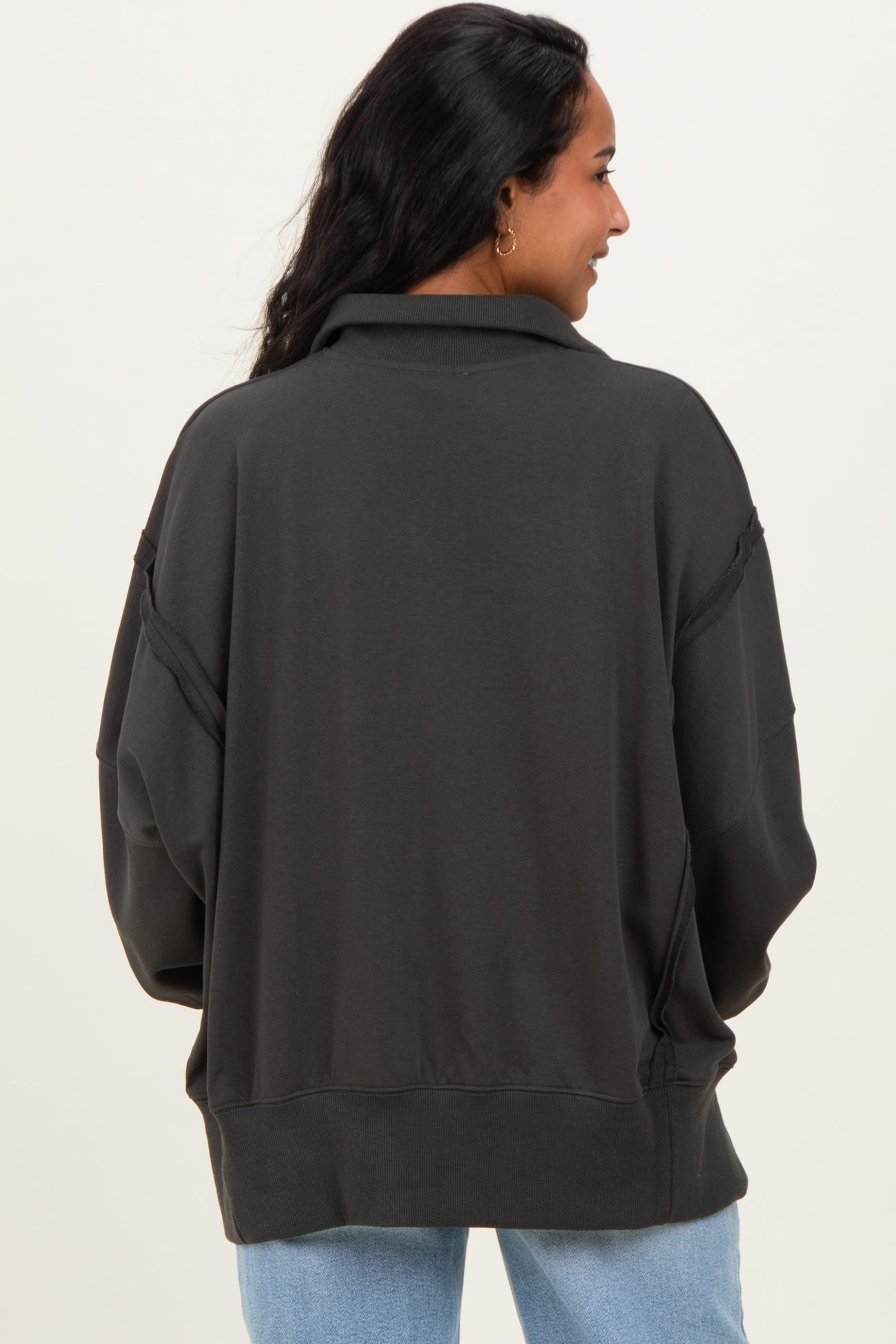 woman wearing a dark gray oversized maternity sweatshirt with a relaxed fit and dropped shoulders