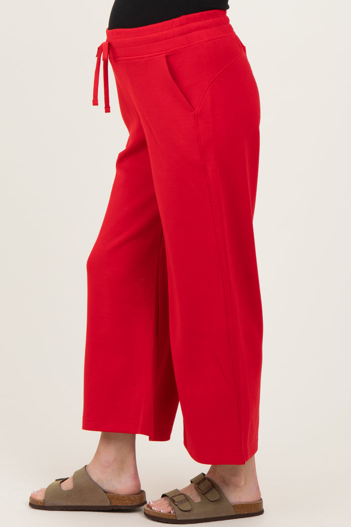 maternity wear red wide leg pants with side pockets and adjustable drawstring waistband, model showing baby bump