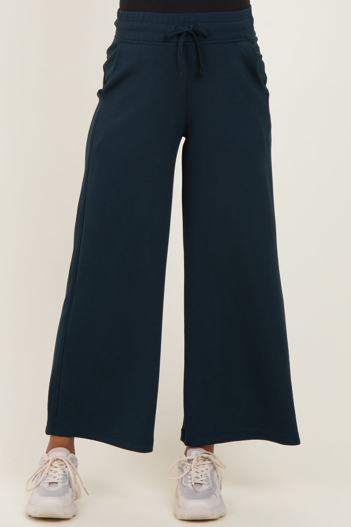 maternity wear navy blue wide-leg sweatpants with an elastic waistband and drawstring, styled with light sneakers