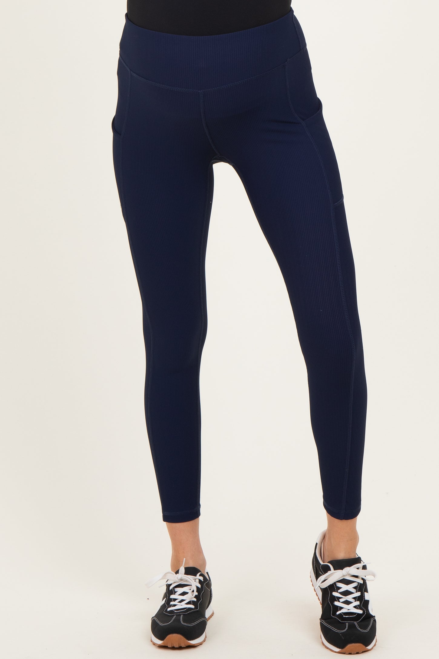 maternity wear navy ribbed leggings with pockets, model wearing black top and athletic shoes
