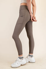 woman wearing brown high-waisted leggings with ribbed texture and paired with white sneakers