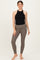 woman wearing a black halter neck maternity top and brown ribbed maternity leggings with side pockets