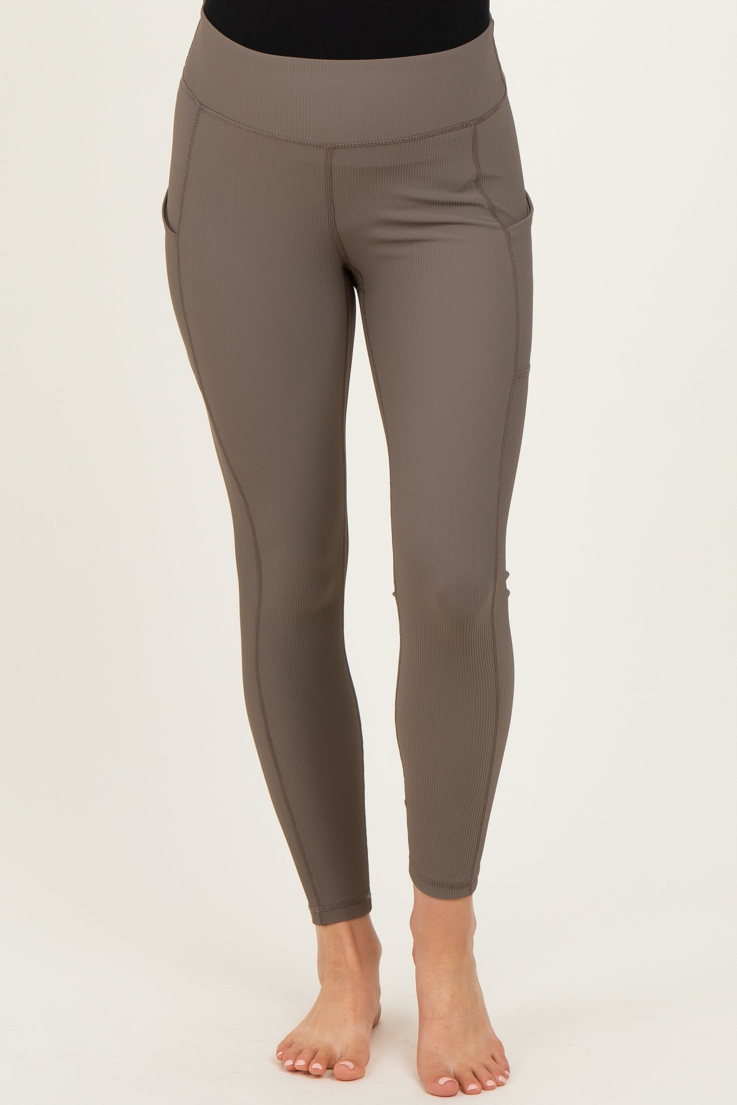 maternity wear in a mocha brown color, featuring a high waistband and side pockets, model wearing the leggings