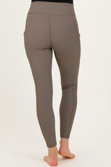 woman wearing maternity active leggings in taupe with a stretchy high waistband and side pockets, viewed from the back