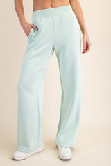 woman wearing mint green wide leg sweatpants with side pockets and an elastic waistband