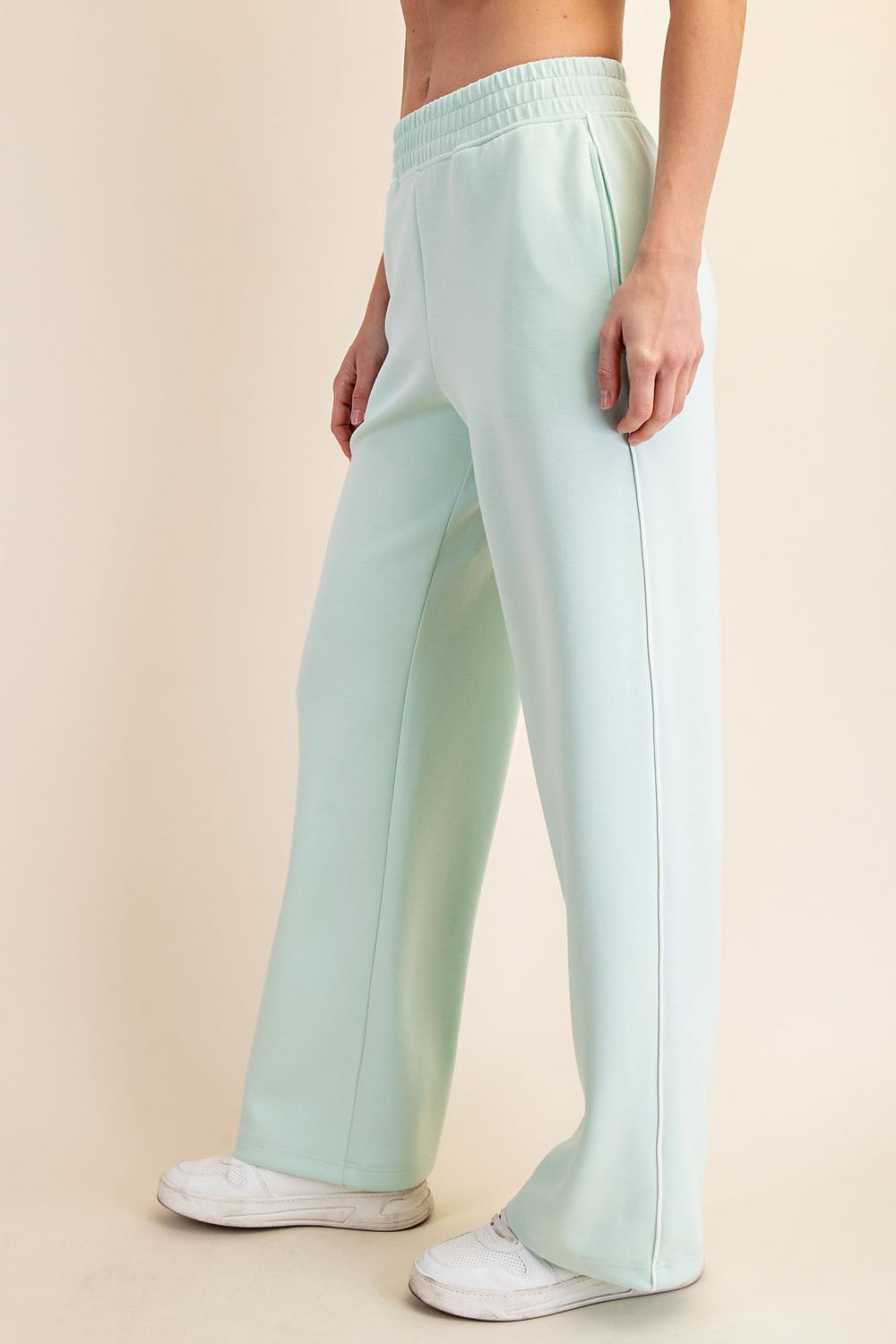woman wearing light mint green wide-leg sweatpants with an elastic waistband and side pockets