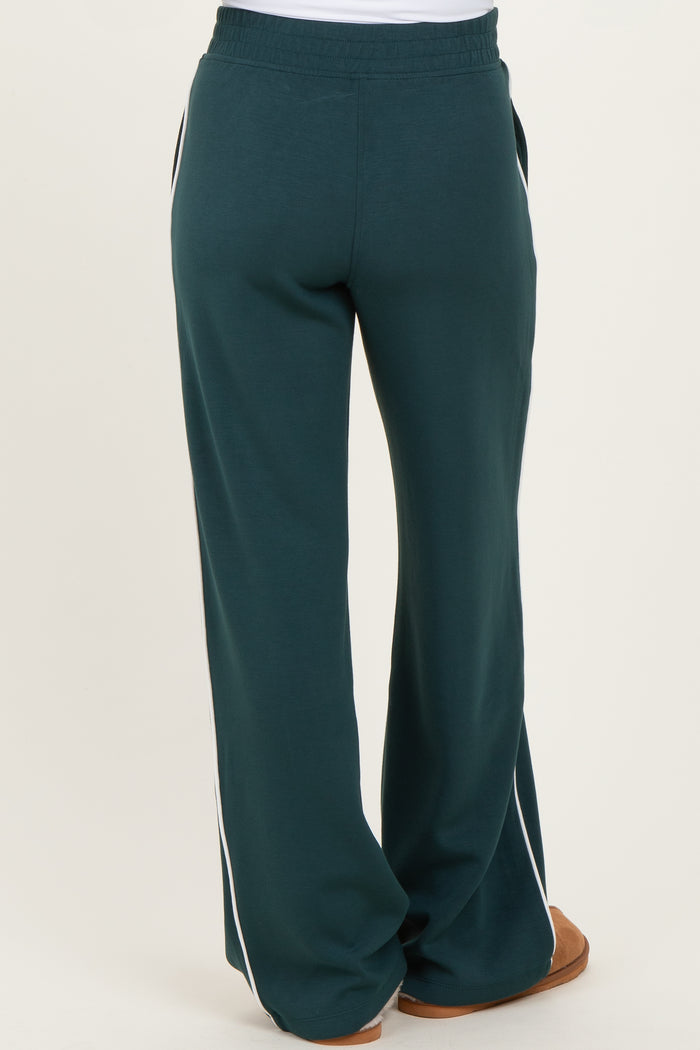 woman wearing green maternity sweatpants with side stripes, showing the back view
