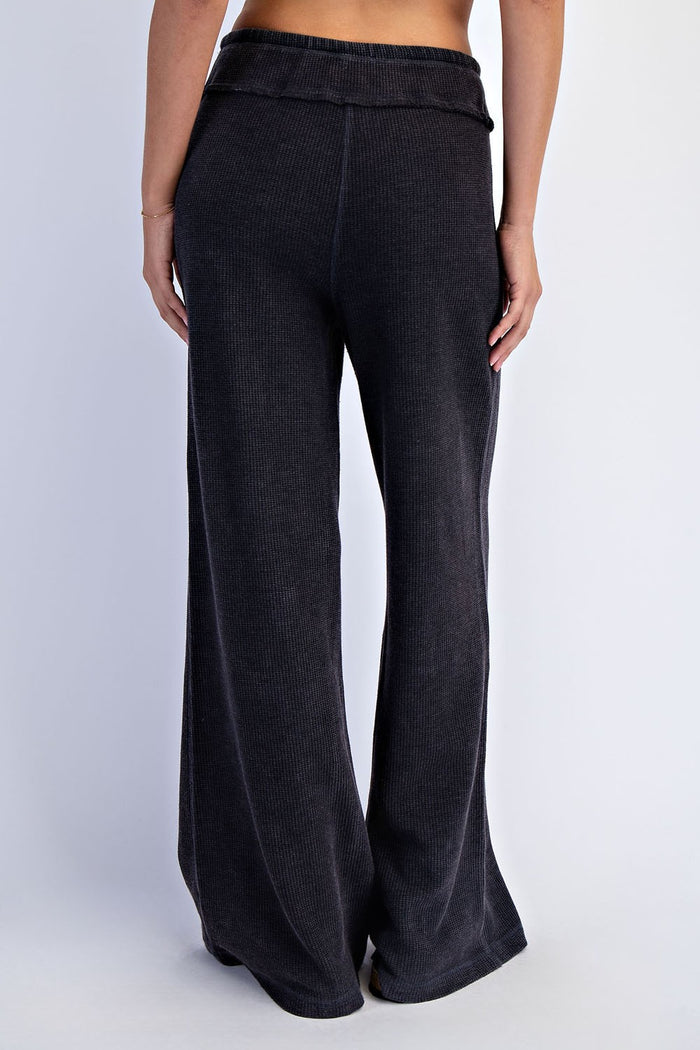 woman wearing black ribbed wide-leg pants, shown from the back
