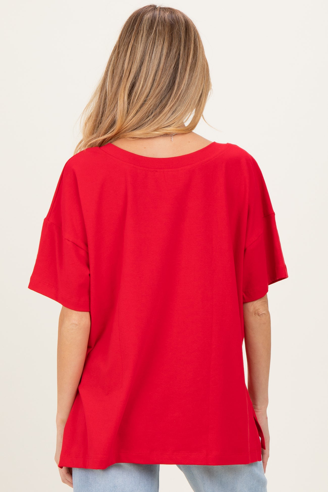 woman wearing a red oversized maternity t-shirt with a relaxed fit and short sleeves