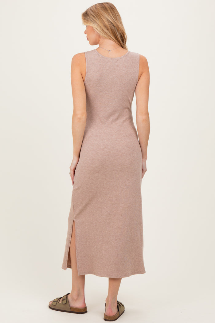 woman wearing a mauve ribbed maxi maternity dress with a side slit, showing her back and wearing slide sandals