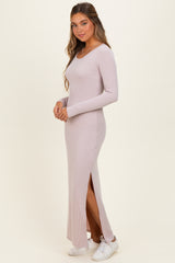 woman wearing a light pink long sleeve ribbed maxi dress with a side slit and white sneakers