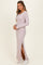 woman wearing a light pink long sleeve ribbed maxi dress with a side slit and white sneakers