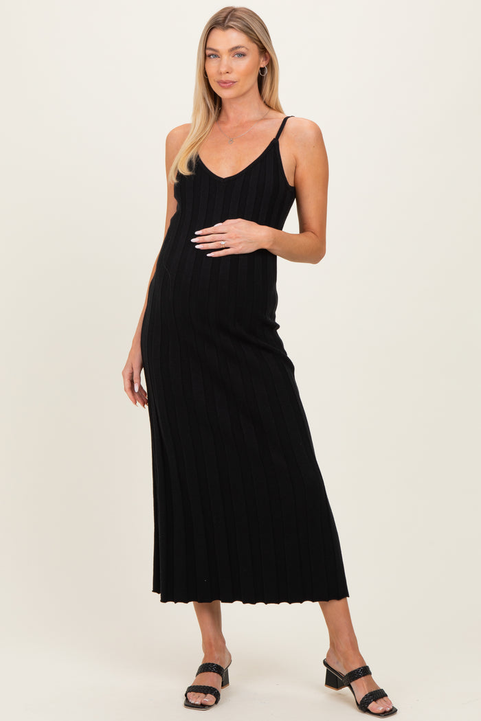 woman wearing a black ribbed maternity maxi dress with adjustable straps and showcasing her baby bump