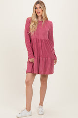 woman wearing a pink striped long sleeve dress with a tiered skirt and white sneakers