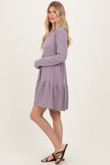 woman wearing a lavender striped long sleeve tiered dress with a loose fit and sandals