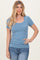 woman wearing a light blue short sleeve ribbed top with a scoop neckline and fitted silhouette