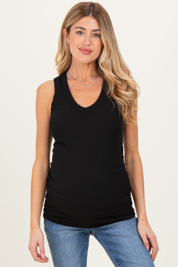 woman wearing a black sleeveless maternity top with a v-neck and a visible baby bump