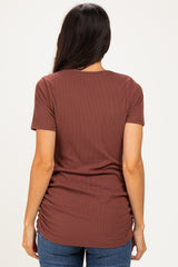 woman wearing a rust brown short sleeve ribbed top with gathered side details